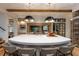 Bright kitchen island with stone countertops, modern seating, stainless appliances, and wine storage at 170 Autry Trl, Johns Creek, GA 30022