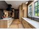 Modern kitchen with wood cabinets, stone countertops, black appliances, and stainless-steel accessories at 170 Autry Trl, Johns Creek, GA 30022