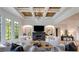 Chic living room featuring a fireplace, coffered ceiling, large windows, and modern decor at 170 Autry Trl, Johns Creek, GA 30022