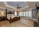 Spacious main bedroom with hardwood floors, tray ceilings, fireplace, and four-poster bed at 170 Autry Trl, Johns Creek, GA 30022