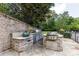 A fully equipped outdoor kitchen with stone countertops and stainless steel appliances at 170 Autry Trl, Johns Creek, GA 30022