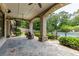 Covered outdoor patio with a pool view, stone columns, and an iron spiral staircase to the garden at 170 Autry Trl, Johns Creek, GA 30022