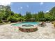 A stunning pool with jacuzzi and a shaded cabana surrounded by lush greenery and stone pavers at 170 Autry Trl, Johns Creek, GA 30022