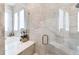 Luxurious bathroom featuring marble, a glass enclosed shower, and a soaking tub at 4585 Ryker Rd, Cumming, GA 30041
