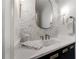Stylish powder room featuring a designer mirror, accent wall, and modern fixtures at 4585 Ryker Rd, Cumming, GA 30041