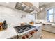 Stylish kitchen with stainless steel range and hood, gray cabinets, and white backsplash at 4585 Ryker Rd, Cumming, GA 30041