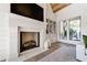 Cozy living room with a stone fireplace, built-in shelves, and a large window with natural light at 4585 Ryker Rd, Cumming, GA 30041