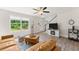 Bright living room featuring hardwood floors, a tan leather sofa, and a large window with backyard views at 2850 Winchester Dr, Cumming, GA 30041