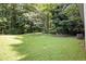 Green backyard with mature trees and vegetation offers a private outdoor space at 5426 Martins Crossing Rd, Stone Mountain, GA 30088
