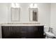 Bathroom featuring a granite countertop vanity with dual mirrors, a toilet and sleek dark cabinets at 1080 Peachtree Ne St # 804, Atlanta, GA 30309