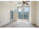 This carpeted bedroom has a ceiling fan and sliding doors open to an urban balcony view at 1080 Peachtree Ne St # 804, Atlanta, GA 30309