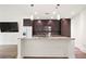 Modern kitchen includes an island with granite counters and stainless steel appliances with dark wood cabinets at 1080 Peachtree Ne St # 804, Atlanta, GA 30309