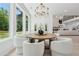 Bright dining area with a round wooden table, stylish chairs, and large windows at 4292 Sardis Church Rd, Buford, GA 30519