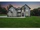 Beautiful modern home at dusk with a lush green lawn and black framed windows at 4292 Sardis Church Rd, Buford, GA 30519