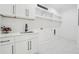 Bright laundry room with white cabinets, quartz countertops, stainless steel sink, and marble floors at 4292 Sardis Church Rd, Buford, GA 30519