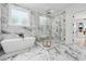 Bright bathroom with marble floors, soaking tub and frameless glass shower at 4292 Sardis Church Rd, Buford, GA 30519