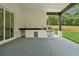 Outdoor kitchen with stainless steel grill, sink, and black countertop on a covered patio at 4292 Sardis Church Rd, Buford, GA 30519