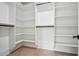 Spacious walk-in closet with custom white shelving and storage and black hardware at 4292 Sardis Church Rd, Buford, GA 30519