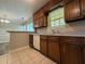Kitchen featuring wood cabinetry, countertops, tile floor, and open view to another room at 8170 Canyon Forge Dr, Riverdale, GA 30274