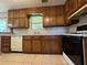 Kitchen featuring wood cabinetry, countertops, tile floor, and appliances at 8170 Canyon Forge Dr, Riverdale, GA 30274