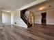 Spacious room with wood floors, a staircase, and doorway leading to the kitchen at 8170 Canyon Forge Dr, Riverdale, GA 30274