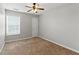 Carpeted bedroom featuring a ceiling fan, window, and neutral paint at 150 Crestworth Xing, Powder Springs, GA 30127