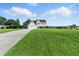 Expansive front yard showcasing a well-maintained lawn and a charming two-story home with a long driveway at 150 Crestworth Xing, Powder Springs, GA 30127