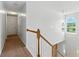 Well-lit hallway with hardwood banister, carpet and arched window at 150 Crestworth Xing, Powder Springs, GA 30127
