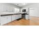 Bright kitchen featuring stainless steel appliances, white cabinets, and light hardwood floors at 150 Crestworth Xing, Powder Springs, GA 30127