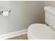 Close up of a modern white toilet next to a tiled floor and gray wall at 150 Crestworth Xing, Powder Springs, GA 30127