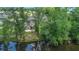 View of home's back exterior overlooking the pond, surrounded by lush greenery and mature trees at 297 Aylesbury Blvd, Mcdonough, GA 30252
