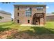 Rear of the brick home with a wooden deck, concrete patio and large windows at 297 Aylesbury Blvd, Mcdonough, GA 30252