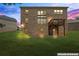 Rear of the brick home with a wooden deck, concrete patio and large windows at dusk at 297 Aylesbury Blvd, Mcdonough, GA 30252