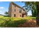 Brick home's rear exterior with a wooden deck and access to the spacious, green backyard at 297 Aylesbury Blvd, Mcdonough, GA 30252