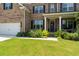 Close up view of two-story brick home's entrance, showcasing the landscaped front yard at 297 Aylesbury Blvd, Mcdonough, GA 30252