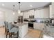 Modern kitchen with white cabinetry, an island with bar seating, and stainless steel appliances at 297 Aylesbury Blvd, Mcdonough, GA 30252