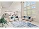Bright living room boasts high ceilings, large windows, modern furnishings, and seamless transition to the kitchen at 297 Aylesbury Blvd, Mcdonough, GA 30252