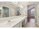 Bright bathroom featuring double sinks with granite countertops and tiled floor and access to walk-in closet at 3707 Vineyards Lake Nw Cir # 22, Kennesaw, GA 30144