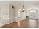 Open dining room with decorative chandelier, wood floors, and fireplace in the living room at 3707 Vineyards Lake Nw Cir # 22, Kennesaw, GA 30144