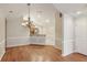 Open dining area with wainscoting, chandelier, and a view into the kitchen with bar seating at 3707 Vineyards Lake Nw Cir # 22, Kennesaw, GA 30144