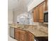 Well-lit kitchen featuring stone backsplash, granite countertops, stainless steel appliances and wooden cabinets at 3707 Vineyards Lake Nw Cir # 22, Kennesaw, GA 30144