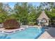 Community pool featuring a gazebo, lounge chairs, and mature shade trees at 3707 Vineyards Lake Nw Cir # 22, Kennesaw, GA 30144