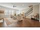 Spacious living room with a fireplace, staircase, and hardwood floors bathed in natural light at 1598 Aldworth Se Pl, Marietta, GA 30339