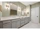 Double vanity with framed mirrors in a luxurious bathroom with marble floors and neutral-toned walls at 1598 Aldworth Se Pl, Marietta, GA 30339