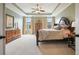 Bright main bedroom with a tray ceiling, carpeted floors, and dual windows for natural light and ventilation at 1598 Aldworth Se Pl, Marietta, GA 30339