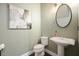 This charming powder room features a pedestal sink and tasteful decorations and an oval mirror at 1598 Aldworth Se Pl, Marietta, GA 30339