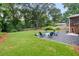 The backyard features a fire pit area with seating, lush grass, and mature trees creating a serene outdoor space at 1895 Flat Shoals Se Rd, Atlanta, GA 30316