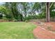 Enjoy the outdoors with lush lawn, mature trees, and a creek bed in the serene backyard at 1895 Flat Shoals Se Rd, Atlanta, GA 30316
