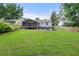 Expansive backyard featuring a screened-in porch, lush lawn, fire pit seating area, and serene wooded views at 1895 Flat Shoals Se Rd, Atlanta, GA 30316