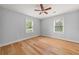 This bedroom features neutral walls, hardwood floors, a ceiling fan, and bright, natural light from two windows at 1895 Flat Shoals Se Rd, Atlanta, GA 30316